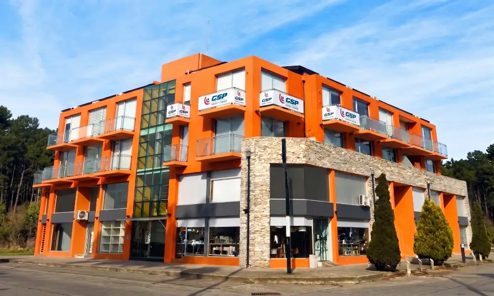 Edificio de la sede central de GSP Seguridad en Pinamar, fachada naranja con cartelería de la empresa